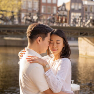 An engaged couple hugging each other in the Amsterdam canals.