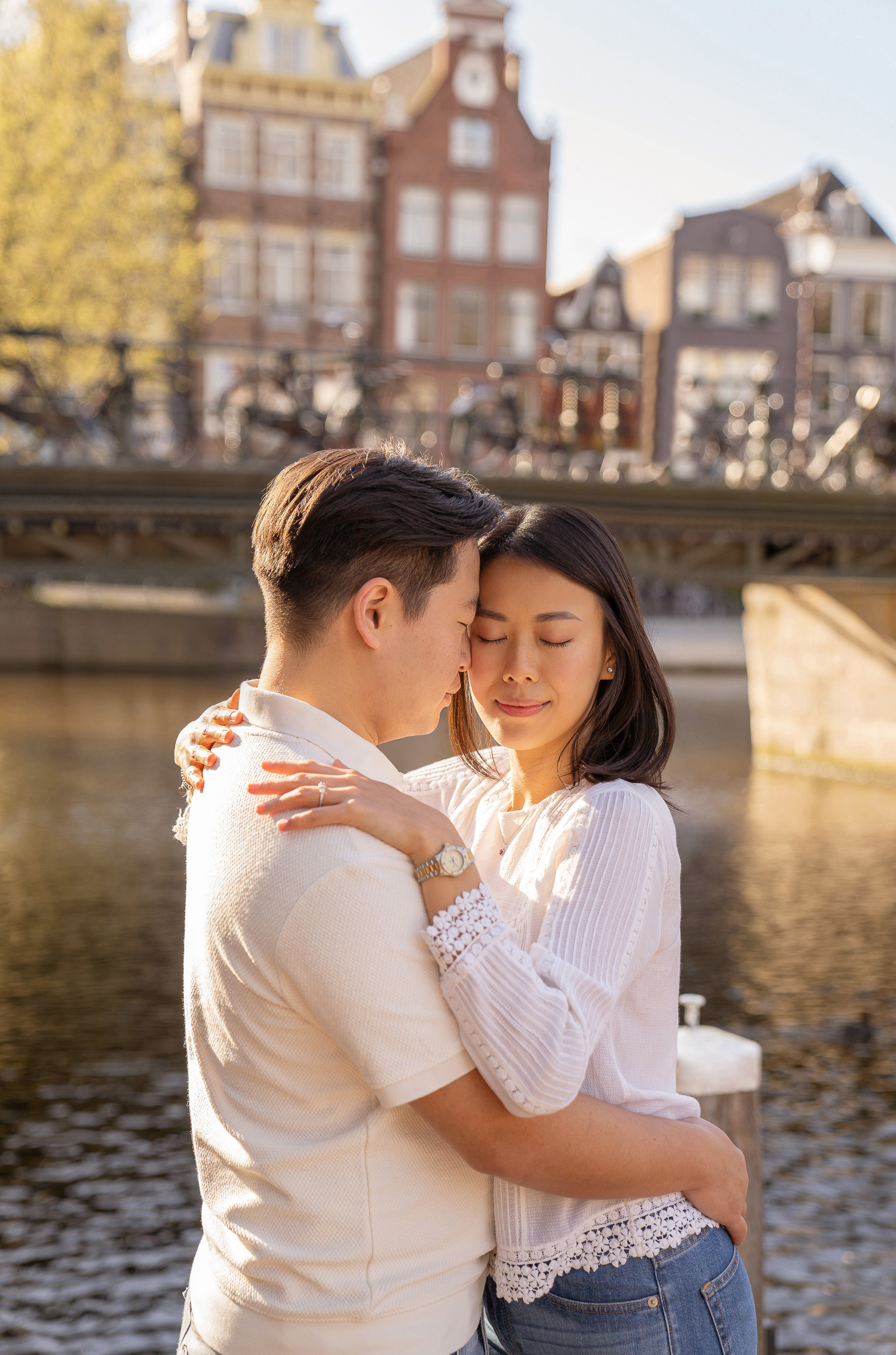 An engaged couple hugging each other in the Amsterdam canals.